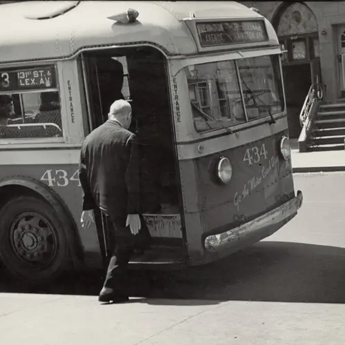 B&W photo of a man stepping into a bus