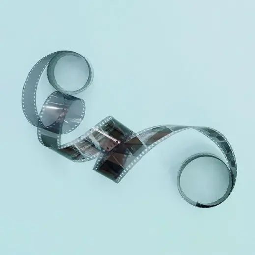A photograph of a roll of film laid out on a blue surface.