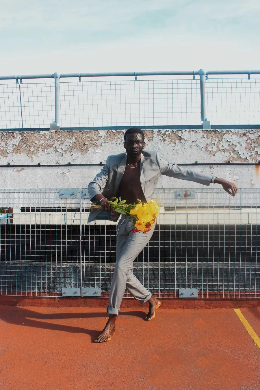 Man dancing with flowers in a sports stadium