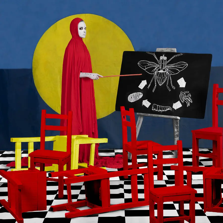 image of a figure dressed in red pointing at a blackboard by Aïda Muluneh from the series The Crimson Echo