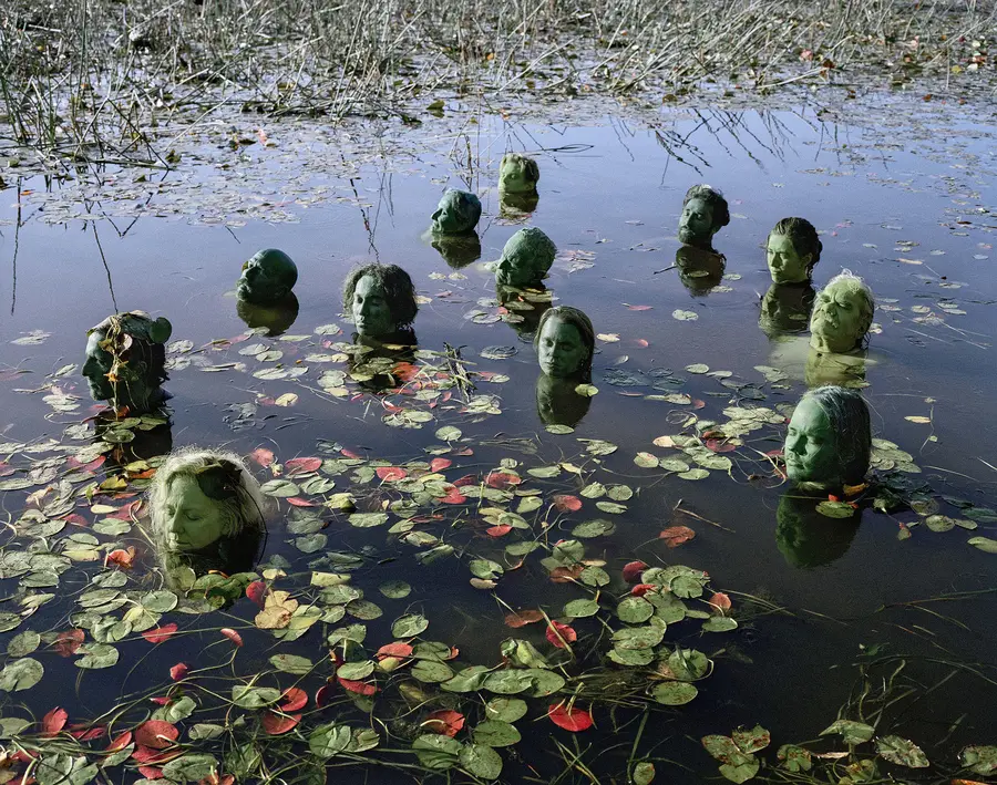 photograph of several heads painted green emerging from a lake by Shoufay Derz