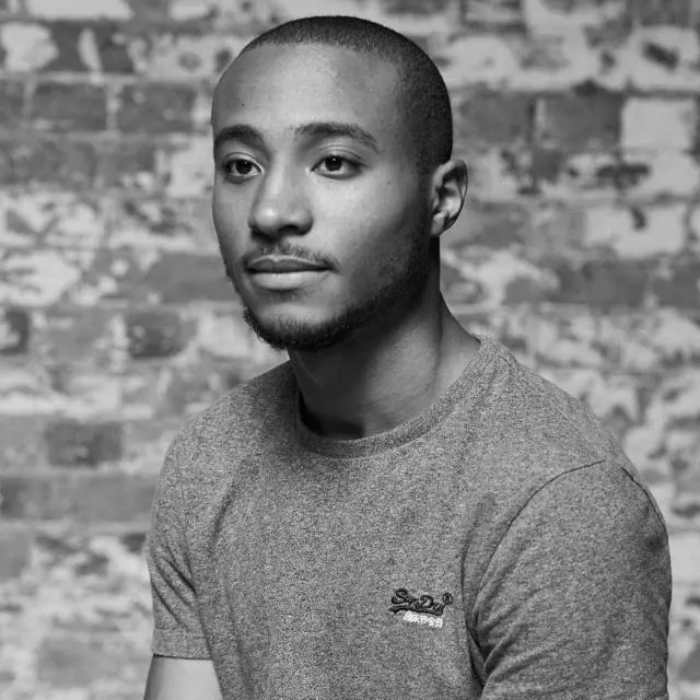 A black and white portrait of a person looking in to the distance. 