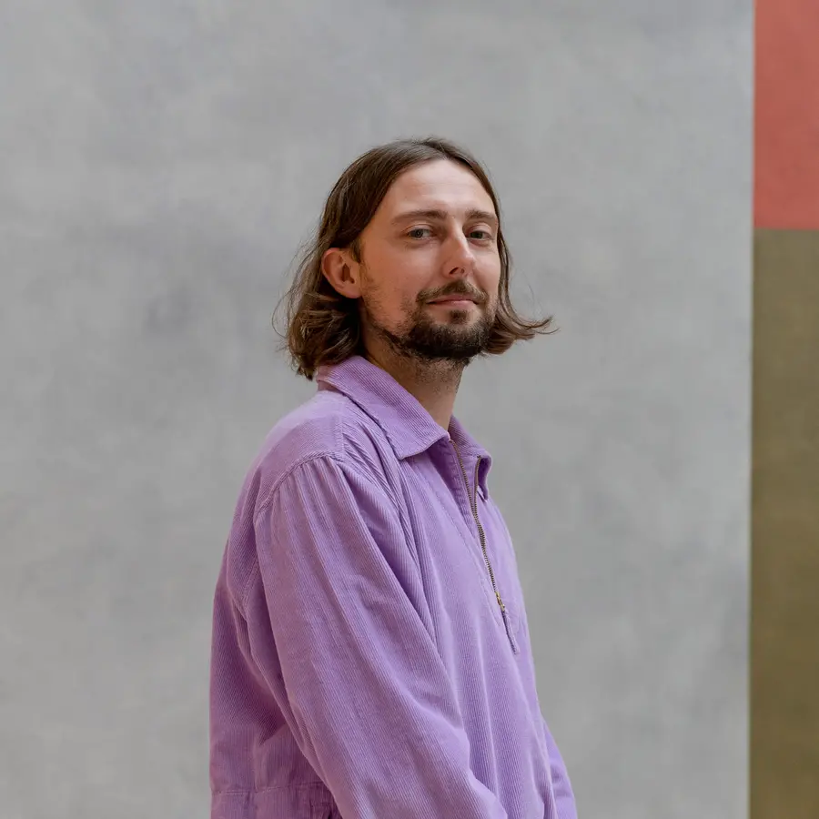 A portrait of a person wearing a purple shirt. 