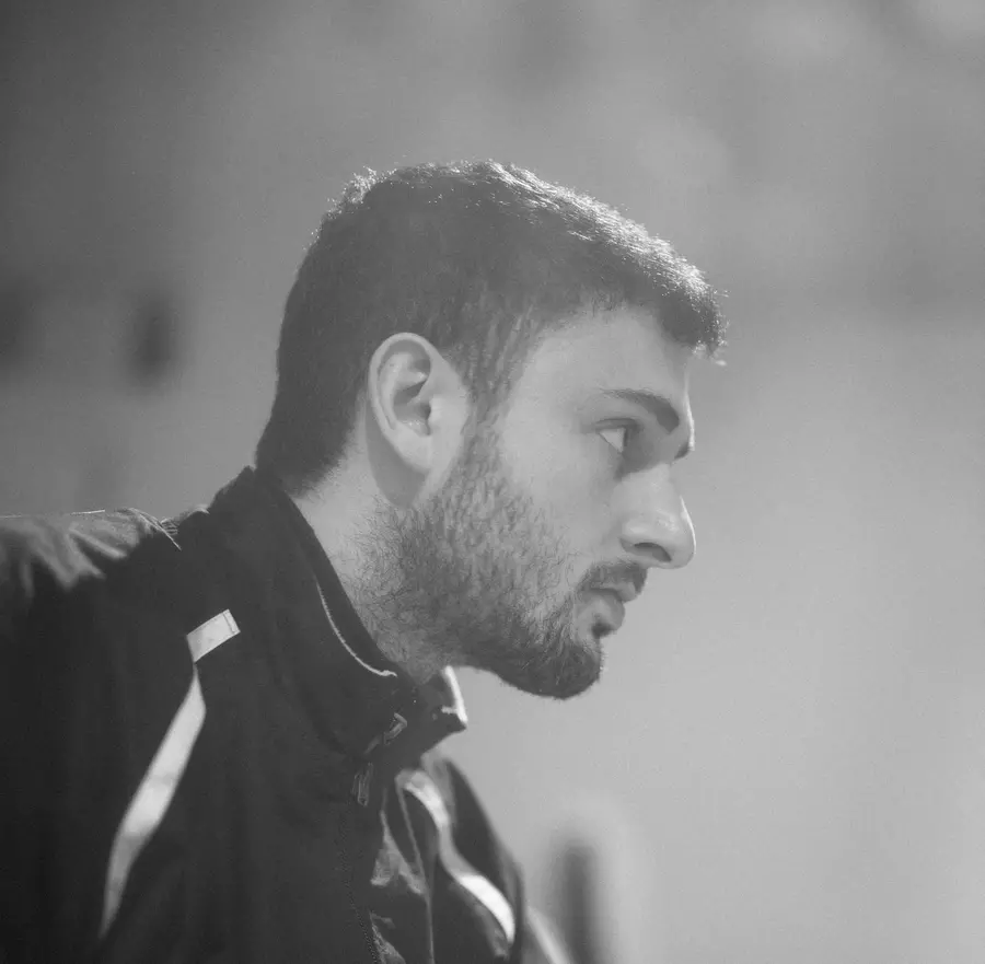 Black and white headshot image of man's side profile. 