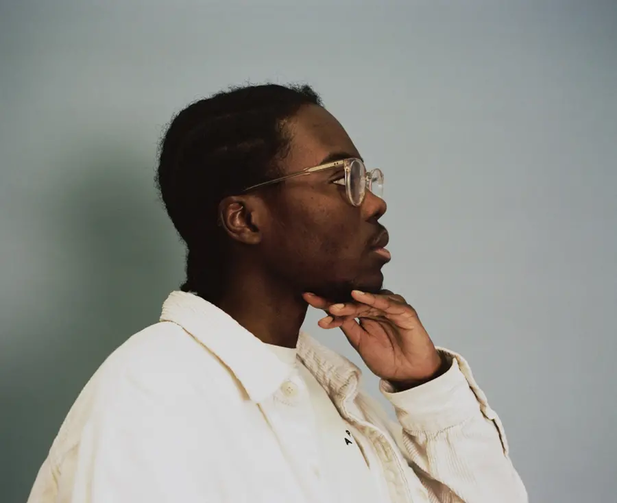 A side profile portrait of a man with his hand on his chin.