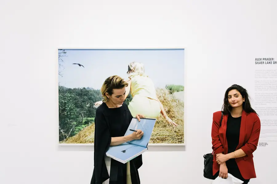 Alex Prager signing an exhibition catalogue at her opening