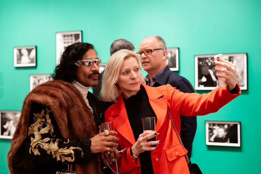 Two people taking a selfie at an exhibition opening