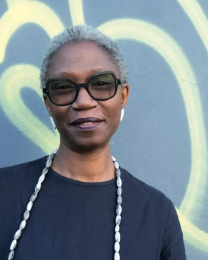 a portrait of a woman with short grey hair and glasses on.