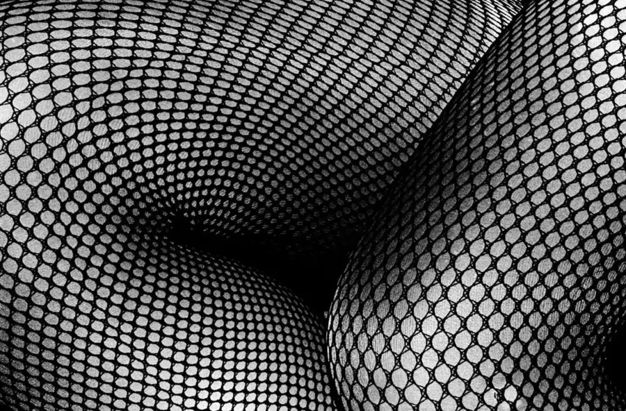 Black and white photograph of a close up of legs wearing black stockings