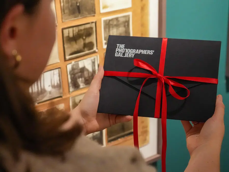 An image of a pair of hands opening a gift membership pack and taking out a membership card.