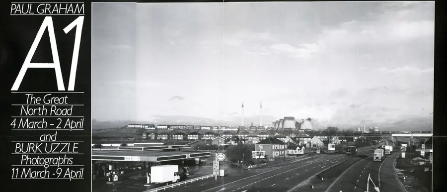 Black white A1 photograph of a view above rooftops to a urban skyline.
