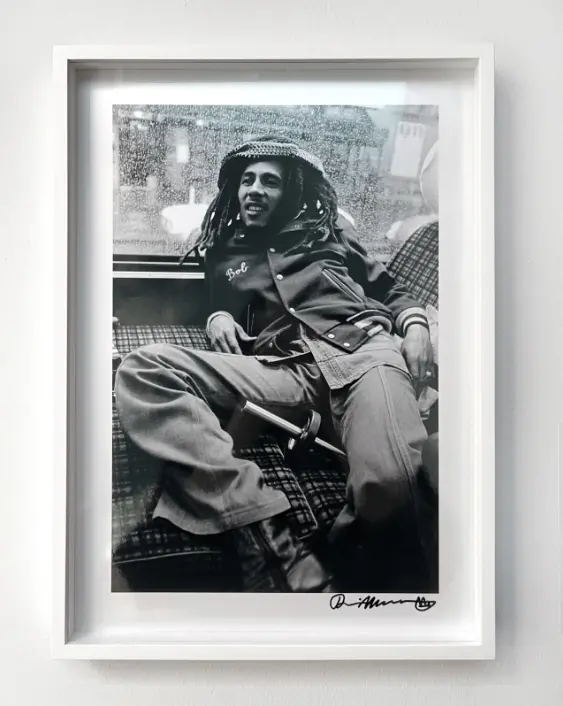Framed black and white print of Bob Marley relaxing on his tour bus.