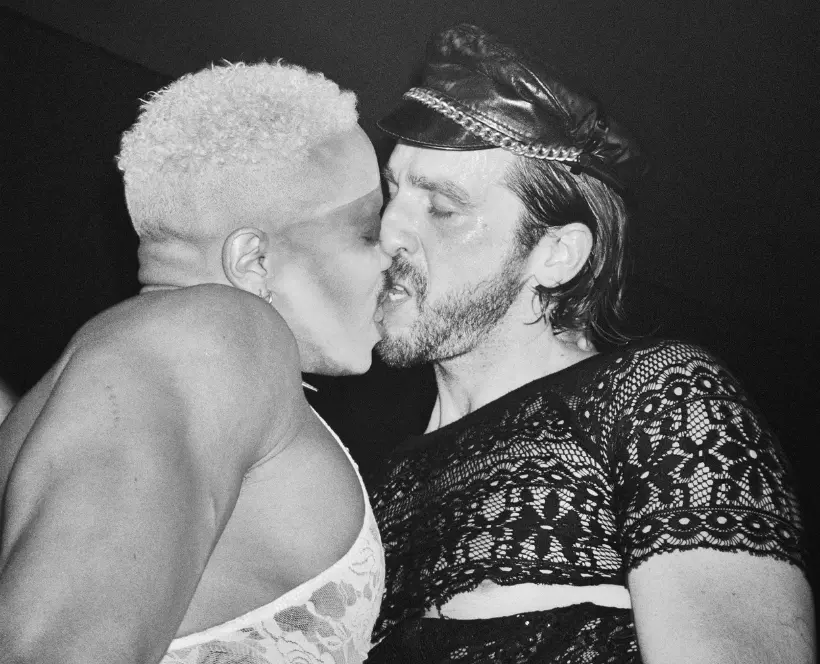 Black and white photograph of two people kissing.