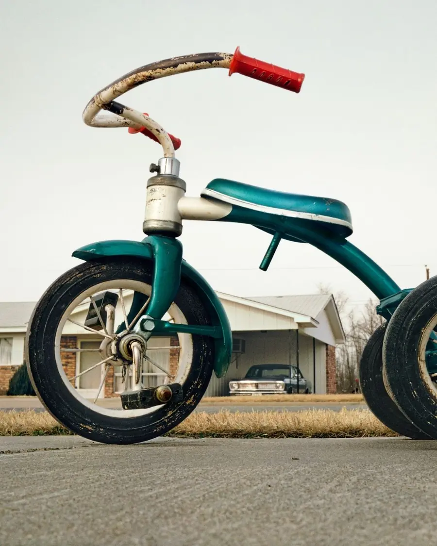 A tricycle in the middle of a suburban street.