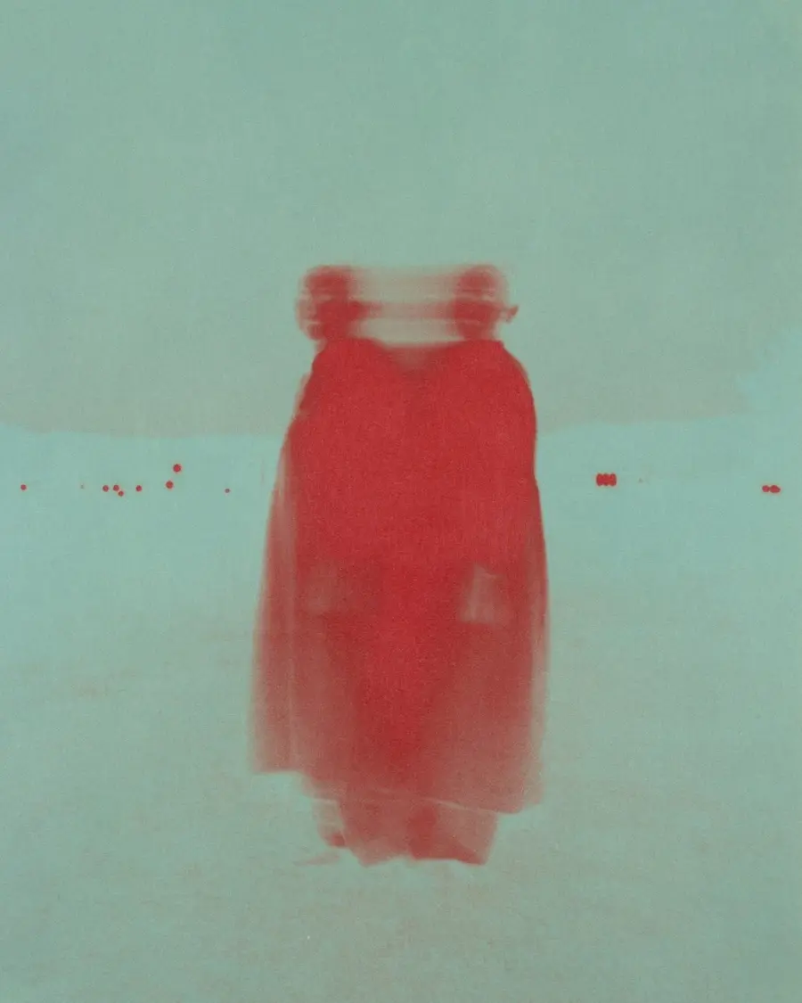 A teal background with two silhouetted figures in red appearing in the centre.