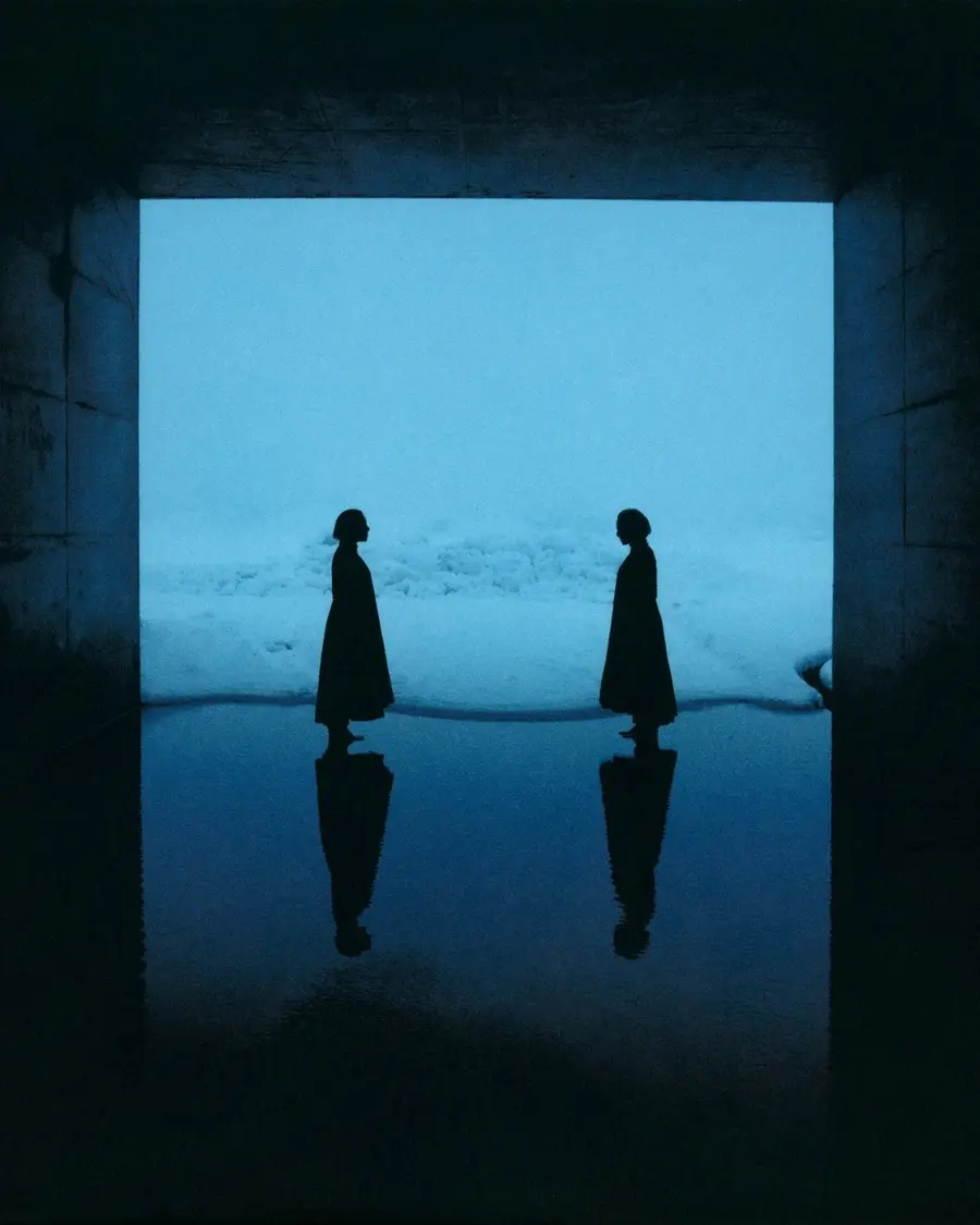 two silhouetted figures face toward each other. 