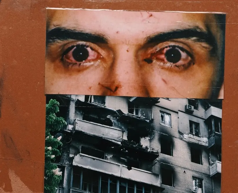 Scan of a collage featuring two photographs: one image being a close up of a man’s bloodshot eyes and injured face, the second image a burnt out building.