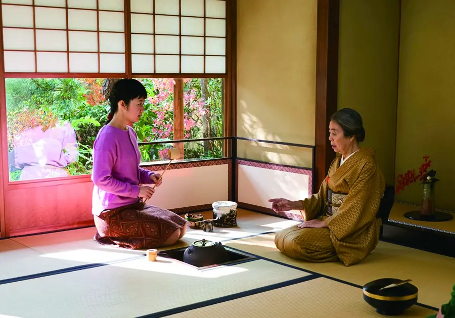 Two people sitting down having a traditional Japanese tea ceremony