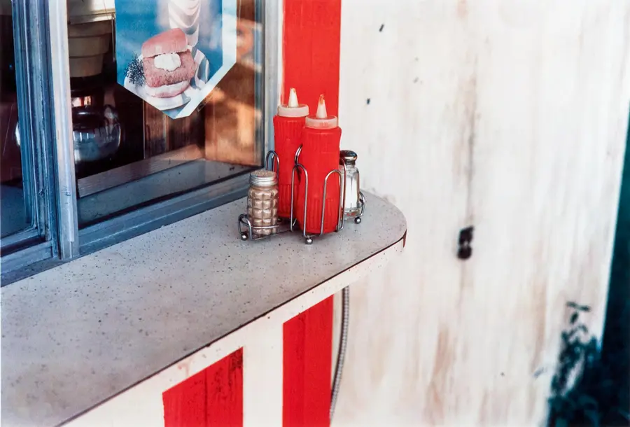 Colour photograph of ketchup bottles and salt and pepper shakers on a countertop.