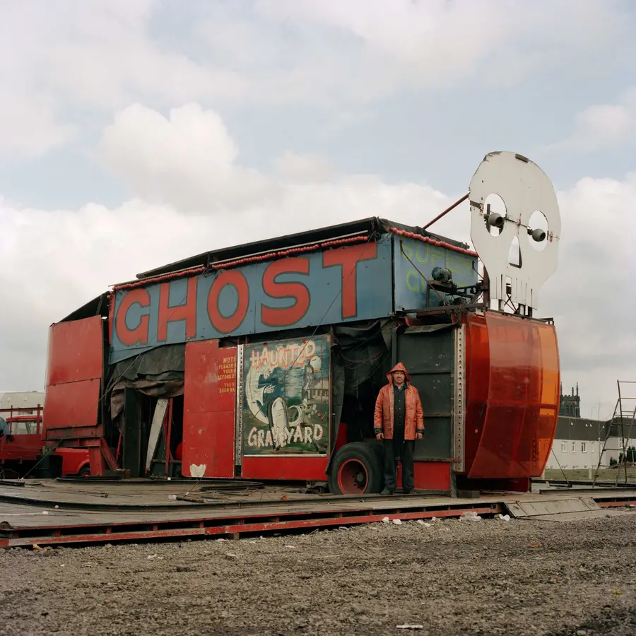 A colour image of a fairground ghost train amusement ride that looks run down.