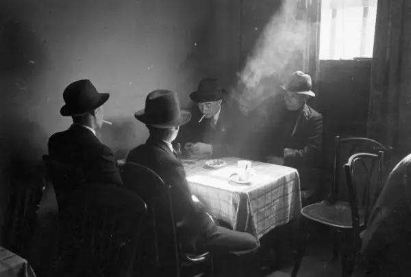 Black and white photo of a group of Chinese merchant seamen sitting around a table in a hostel in Liverpool