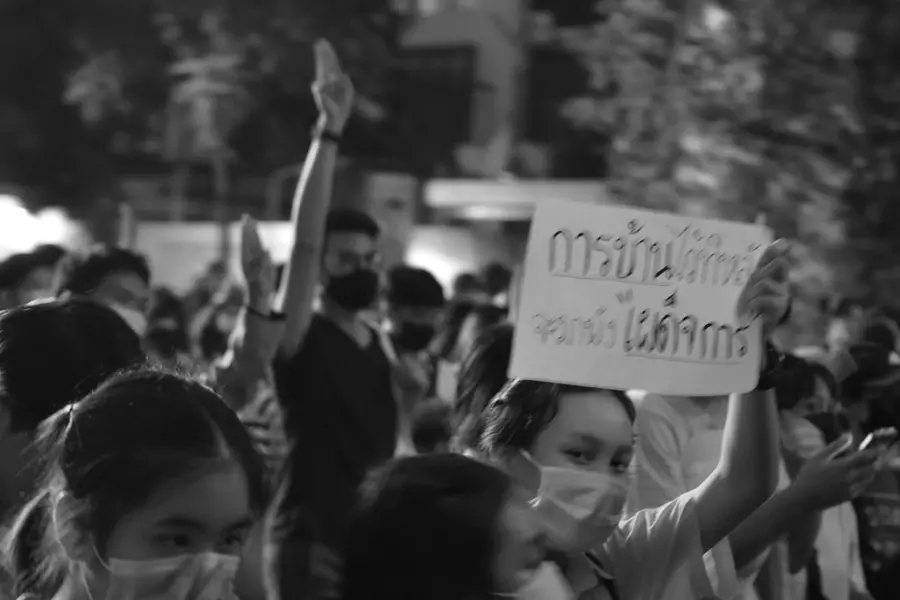 A photograph of people protesting in the street with someone holding a sign.