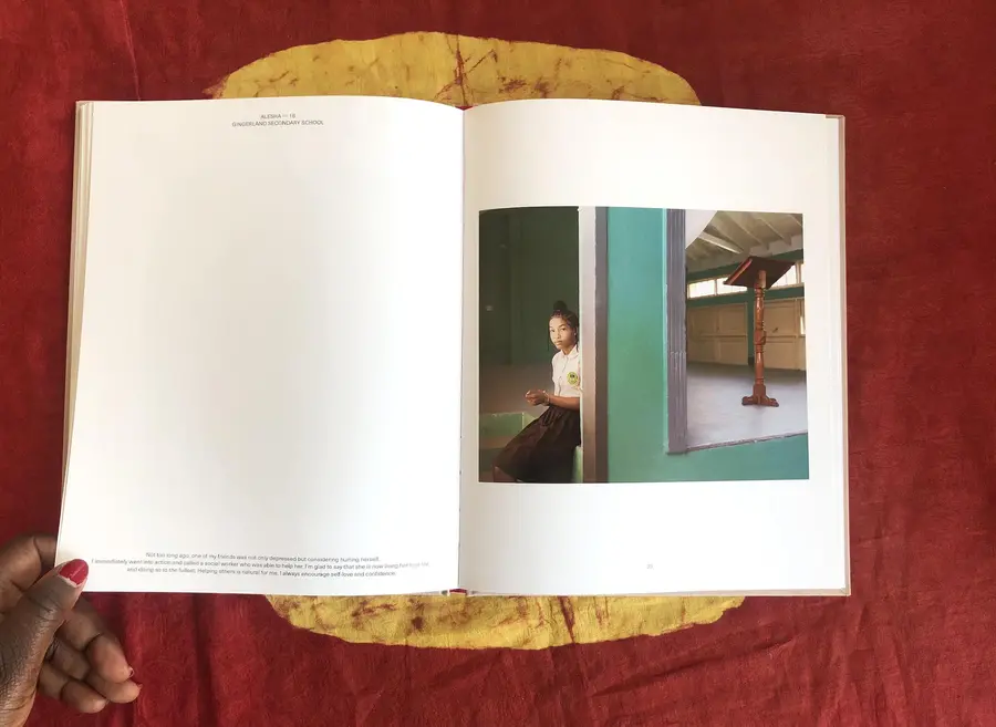 Book open on table with a photograph on a person wearing a school uniform on the left page.