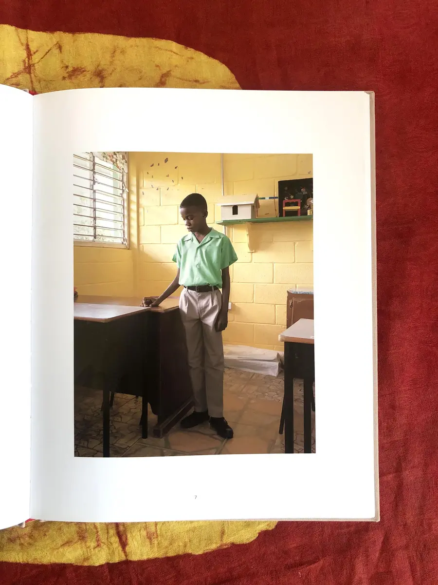 A book placed on a table on a page with a photograph of a person standing next to a table