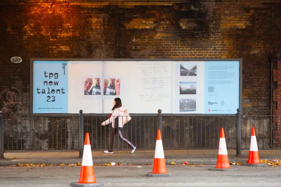 Colour photograph of a street scene of a billboard with colour photographs on the billboard and the text 'TPG new talent 23'
