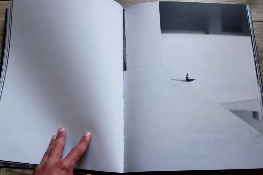 A photograph of a book with a hand holding down a page.