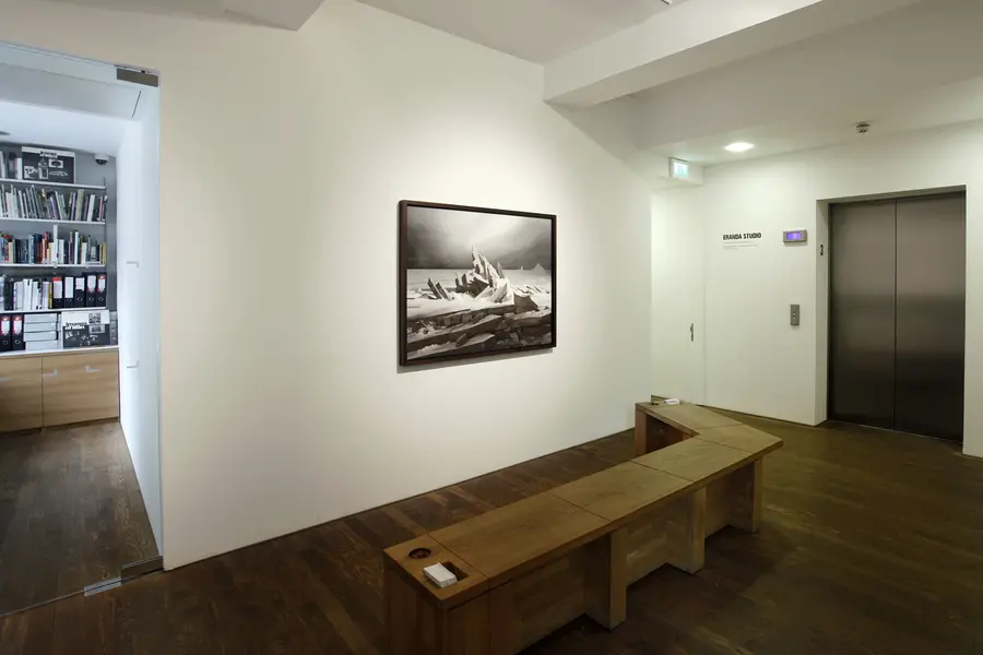 Wooden bench in front of a framed photograph of a constructed icescape.