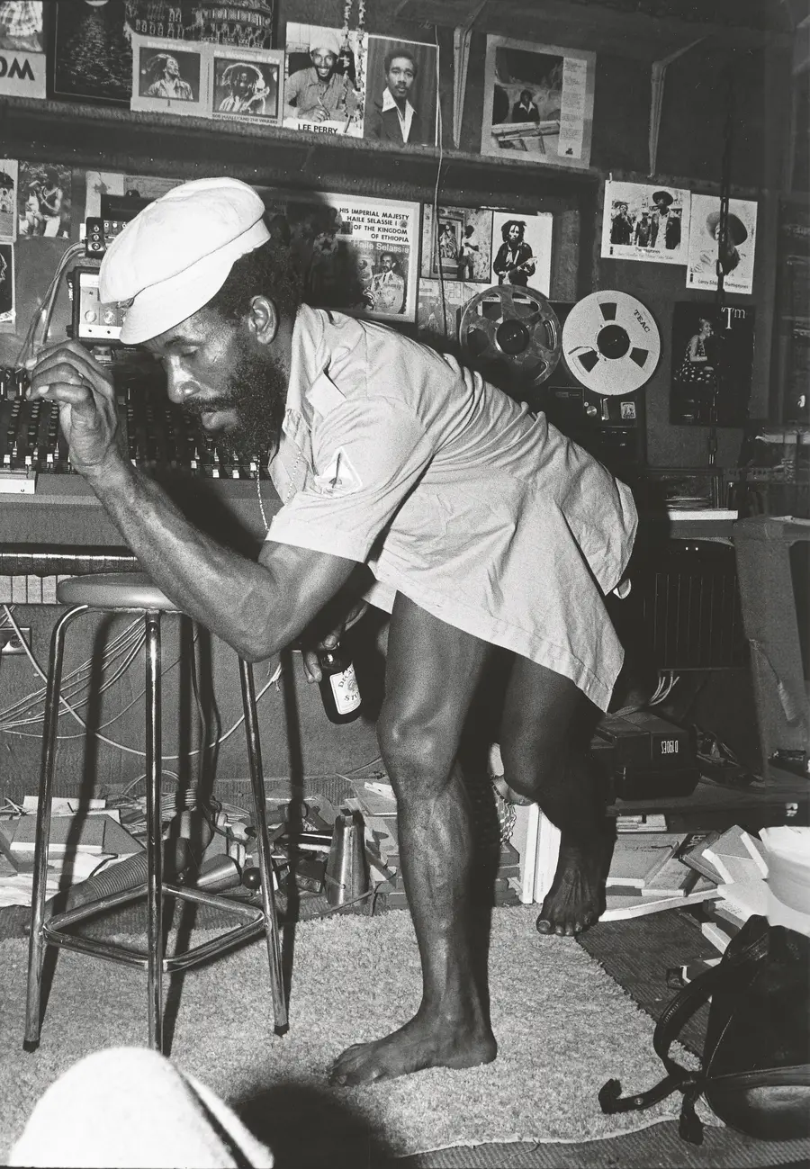 A black and white image of Lee Perry in his studio.