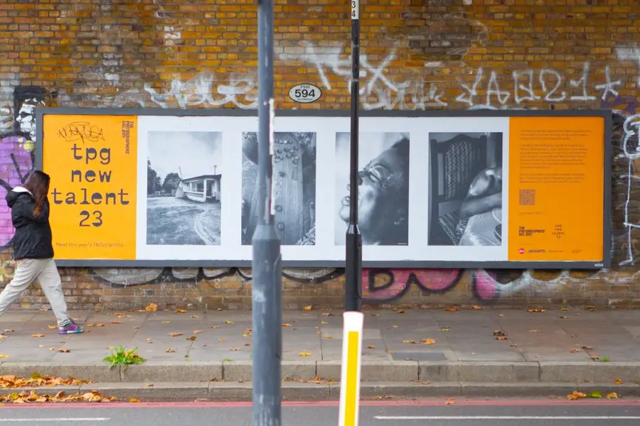 Colour photograph of a billboard with black and white photographs and the text 'TPG new talent 23'