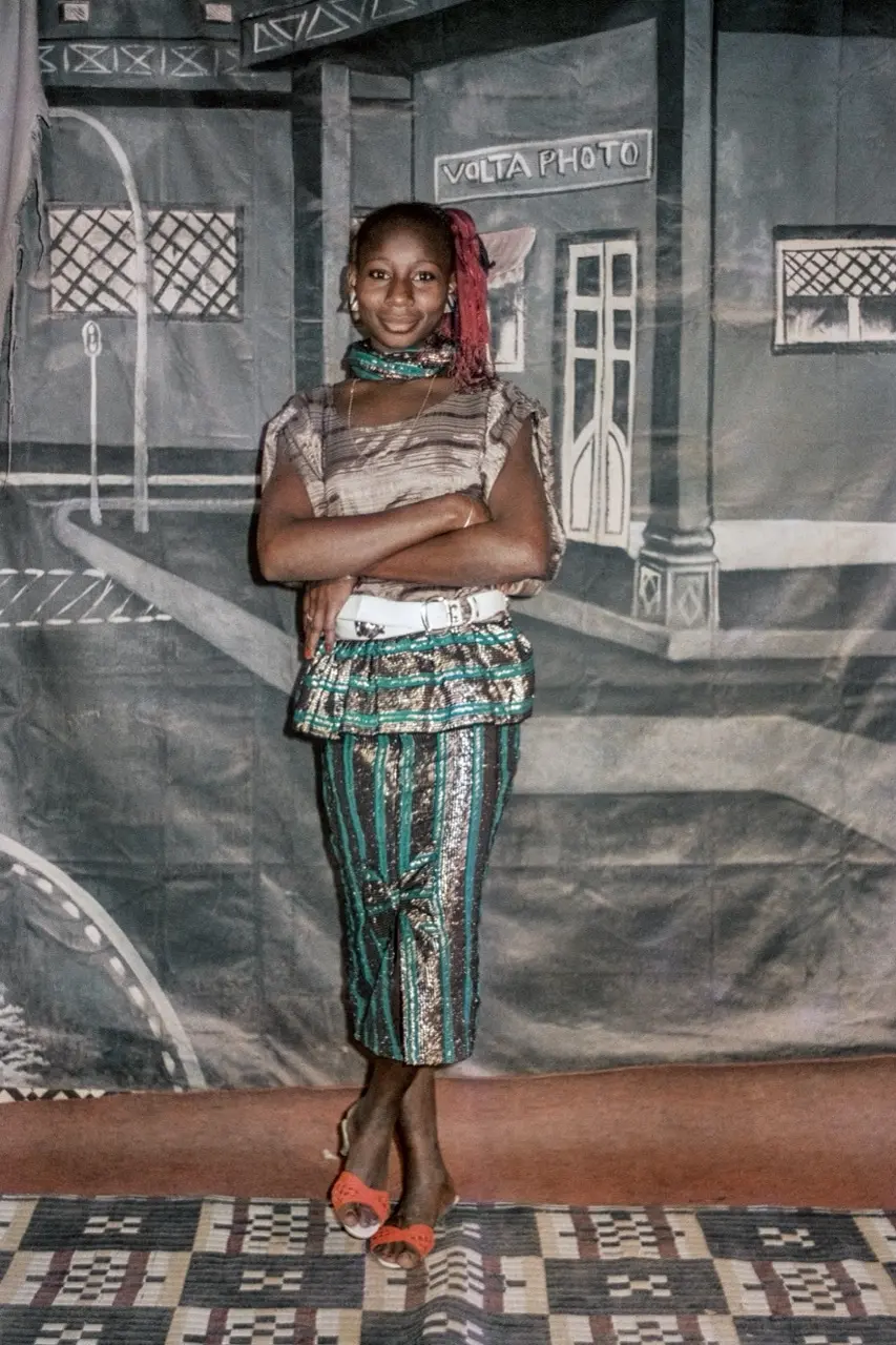 Colour photograph of a young woman posing for the camera wearing fancy clothing.