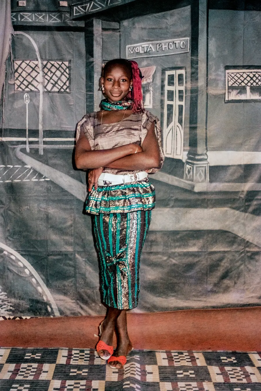 Colour photograph of a young woman posing for the camera wearing fancy clothing.