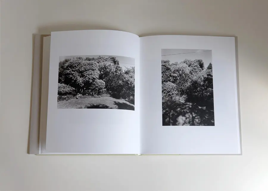 Book opening showing black and white images of a garden.