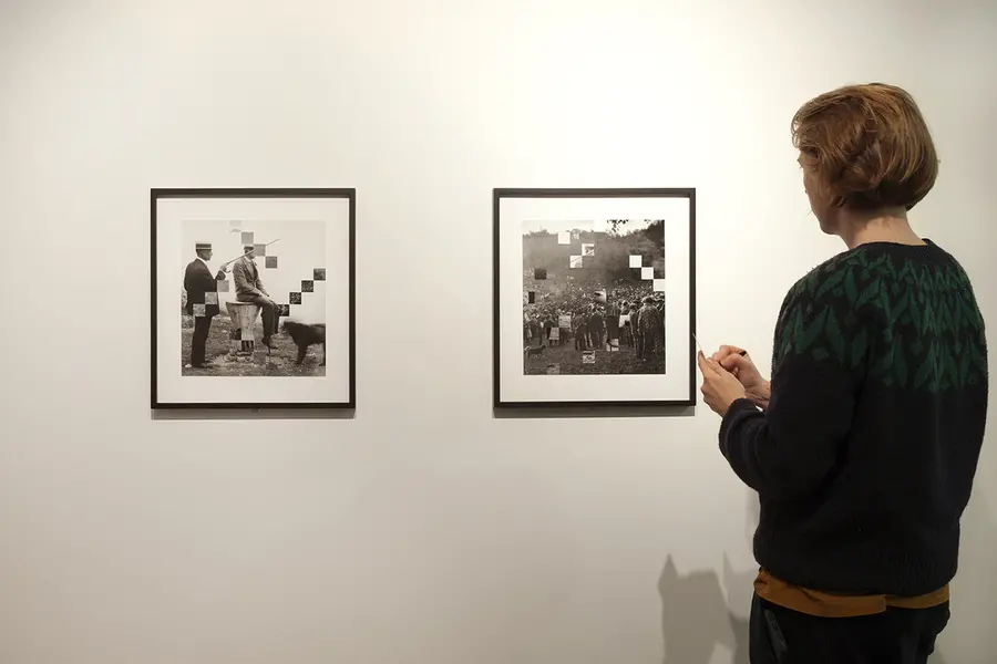 Person standing to the right of two framed photo collages, hung side by side.