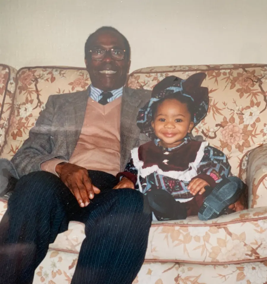 photograph of a young child and an older man sat beside eachother on a sofa