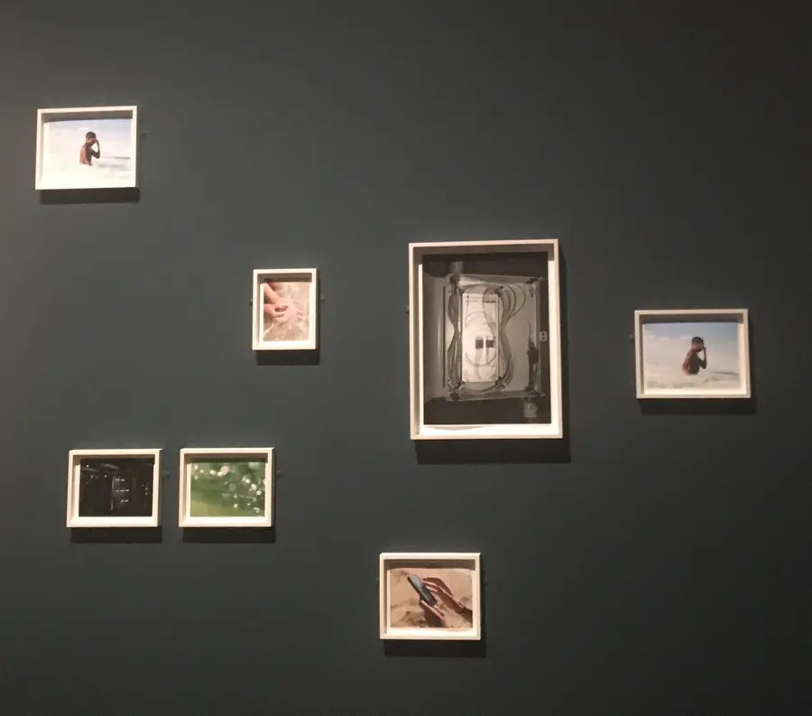 Various photographs framed on a black wall