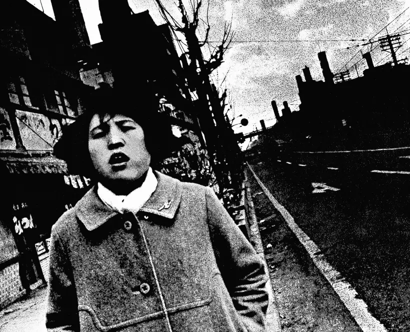 High contrast black and white photograph of a tilted street scene with an open mouthed young person