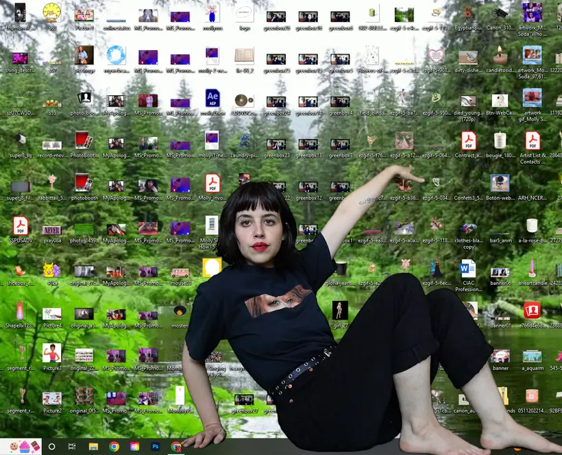 A woman facing the camera shows a screenshot of a computer desktop full of files