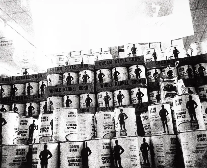 Grainy black and white photograph of a display of tinned food