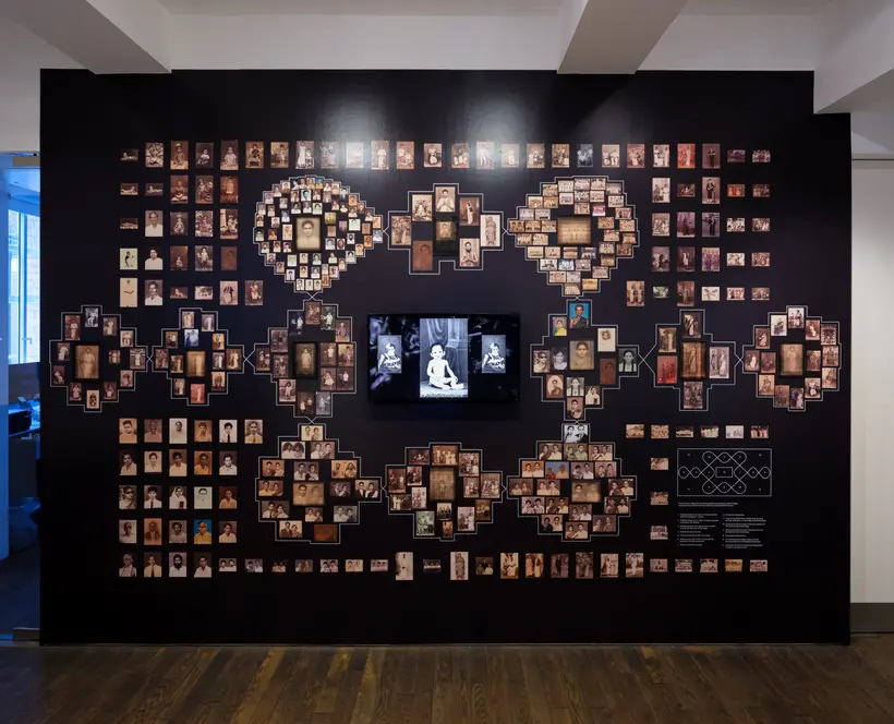 Installation image featuring many archival and family photos arranged into a Kolam pattern.