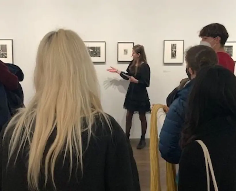 A young person giving a tour of an exhibition. 