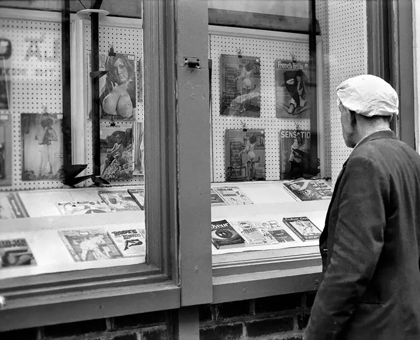 Man looking in a book shop window in Soho. December 1970