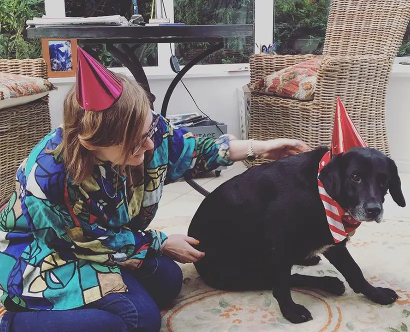 A photo of the photographer and her dog, both wearing party hats