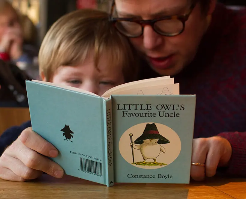 A man and a young boy read a children's book together