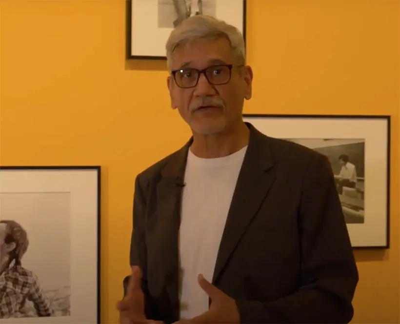 Sunil Gupta faces the camera giving a tour of his retrospective